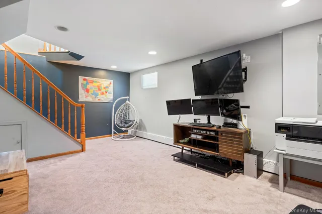 a view of an empty room with furniture and a window