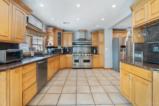 a kitchen with stainless steel appliances granite countertop a stove a sink and a refrigerator
