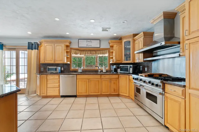 a kitchen with stainless steel appliances granite countertop a stove a sink and a refrigerator