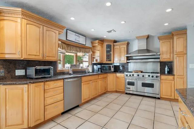 a kitchen with stainless steel appliances granite countertop a stove sink and cabinets