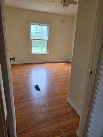 a view of a room with wooden floor and a window