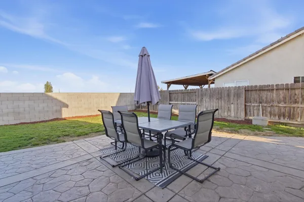a view of a backyard with furniture and garden
