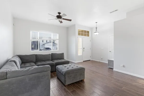 a living room with furniture and a wooden floor