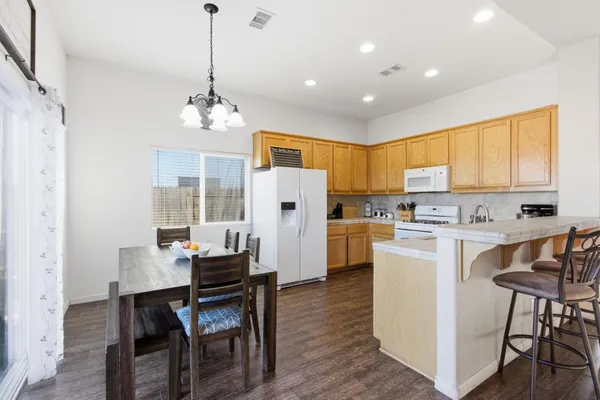 a living room with stainless steel appliances kitchen island granite countertop furniture and a wooden floor