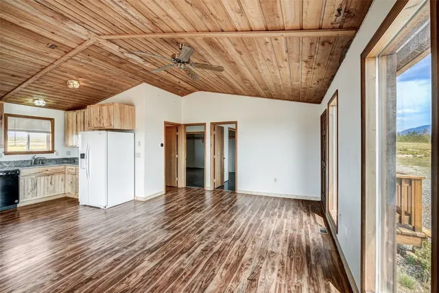 a kitchen with stainless steel appliances a refrigerator and wooden floor