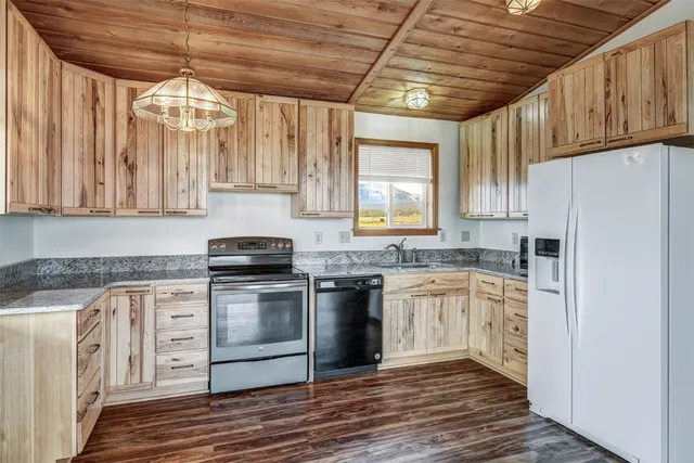 a kitchen with stainless steel appliances granite countertop a stove a refrigerator and a cabinets