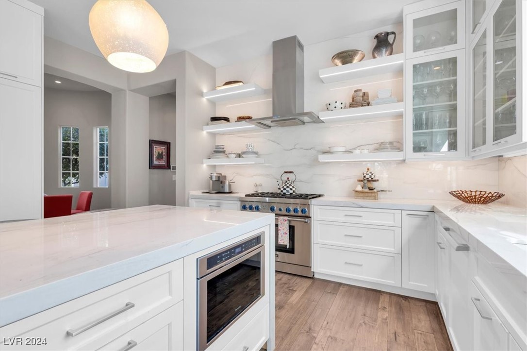 11348 La Madre Ridge Drive Las Vegas, NV 89135 - Photo 19 of 75 Impressive chef's kitchen featuring Quartzite waterfall edge island, matching countertops & ceiling height backsplash, Thermador appliances including built-in fridge, island bar and breakfast nook.