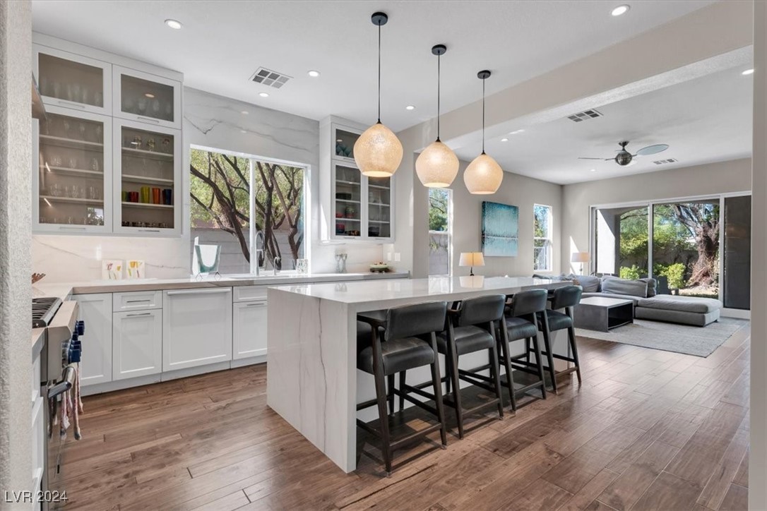 11348 La Madre Ridge Drive Las Vegas, NV 89135 - Photo 2 of 75 Updated chef's kitchen featuring Quartzite waterfall edge island, matching countertops & ceiling height backsplash, Thermador appliances including built-in fridge, island bar and breakfast nook. Featuring updated hardwood floors.