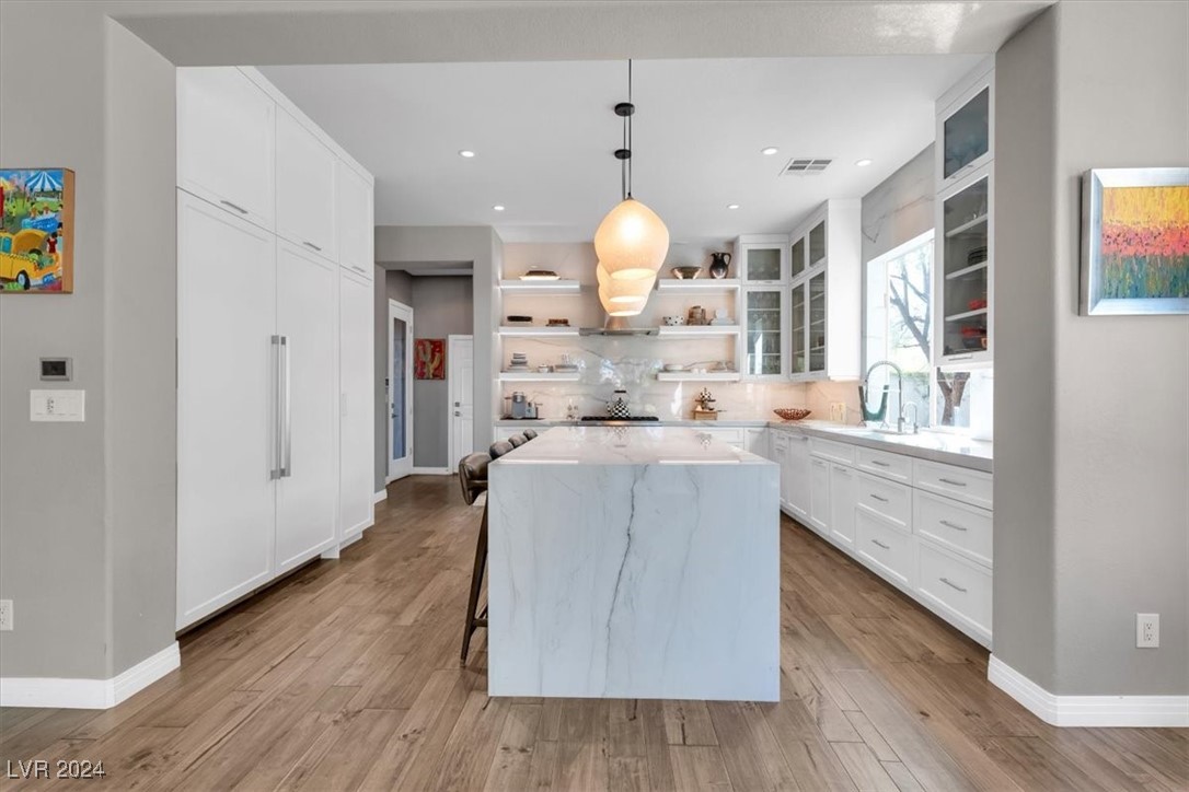 11348 La Madre Ridge Drive Las Vegas, NV 89135 - Photo 21 of 75 Updated chef's kitchen featuring Quartzite waterfall edge island, matching countertops & ceiling height backsplash, Thermador appliances including built-in fridge, island bar and breakfast nook.