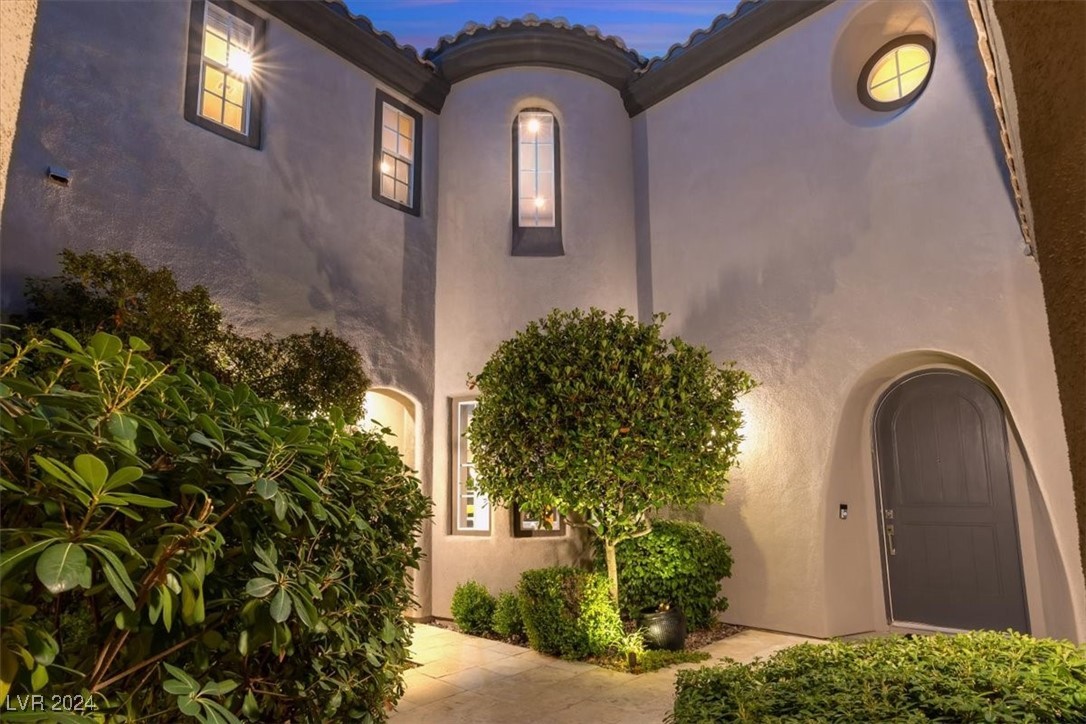 11348 La Madre Ridge Drive Las Vegas, NV 89135 - Photo 42 of 75 Inviting turreted entry leading to a lush courtyard with outdoor lving area and fireplace.
