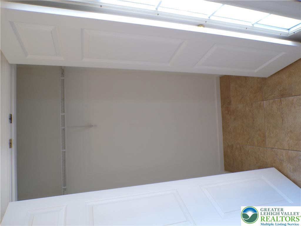 3283 Seip Road Macungie, PA 18062 - Photo 8 of 33 Entrance coat closet with Ample storage solutions elevate this well-lit closet, featuring practical shelving and a tiled floor.