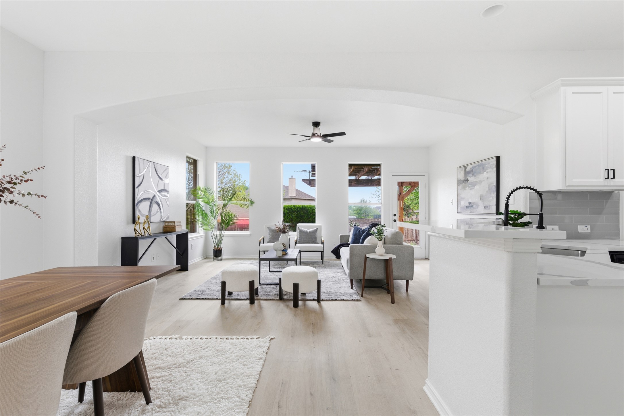 461 Hot Spring Valley Buda, TX 78610 - Photo 2 of 25 The open concept living area features light-colored flooring, white walls, and an arched entryway