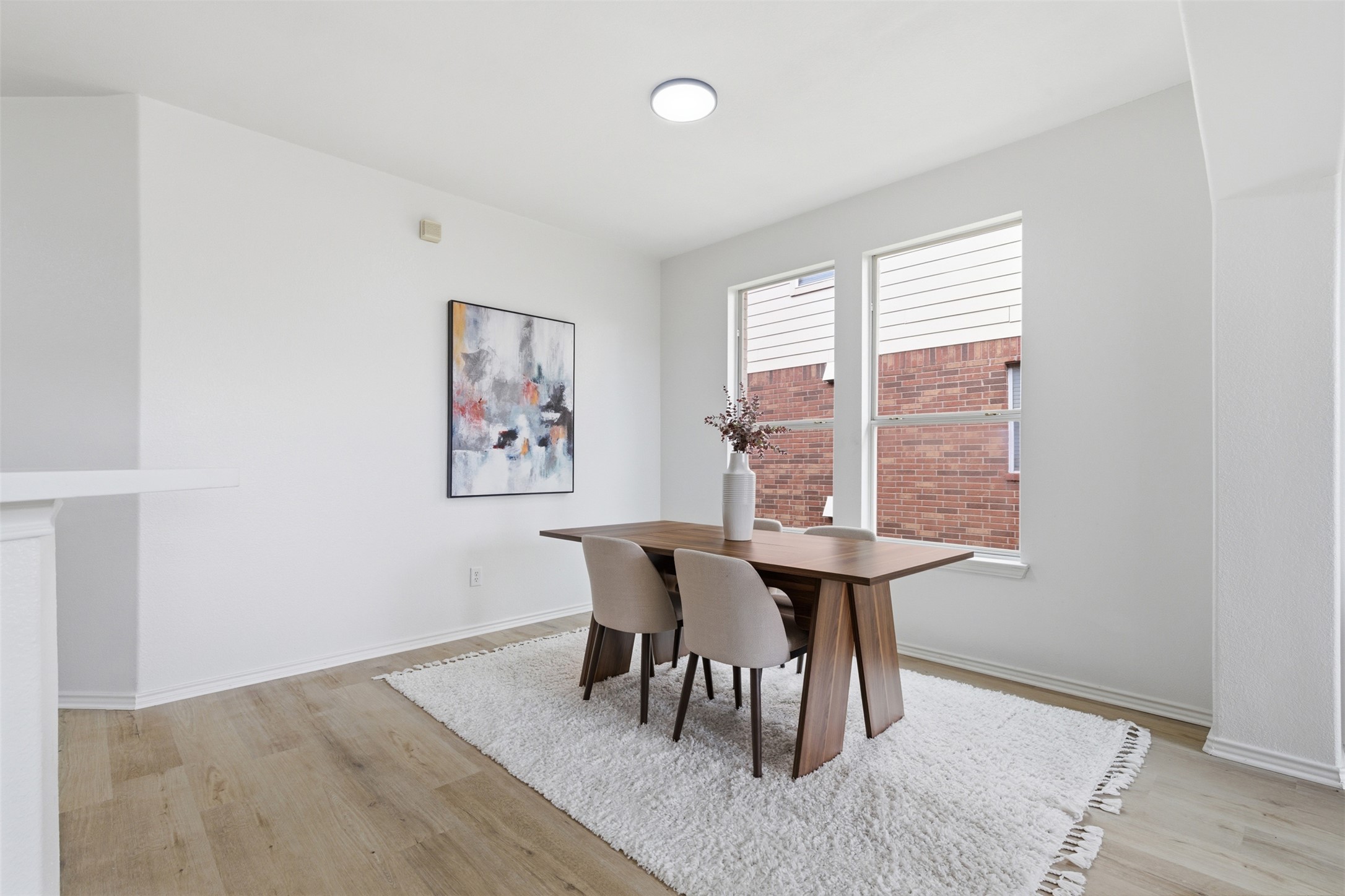461 Hot Spring Valley Buda, TX 78610 - Photo 9 of 25 Dining area featuring hardwood style flooring, white walls, and two windows providing natural light