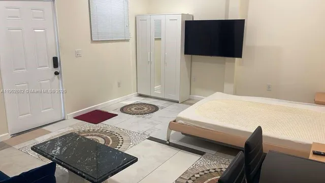 a bedroom with a bed and a flat screen tv