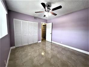 7300 Northwest 5th Court, Unit 106 Margate, FL 33063 - Photo 11 of 13 an empty room with chandelier fan and windows