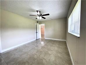 7300 Northwest 5th Court, Unit 106 Margate, FL 33063 - Photo 8 of 13 an empty room with a window and a fan