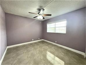 7300 Northwest 5th Court, Unit 106 Margate, FL 33063 - Photo 10 of 13 an empty room with windows and fan