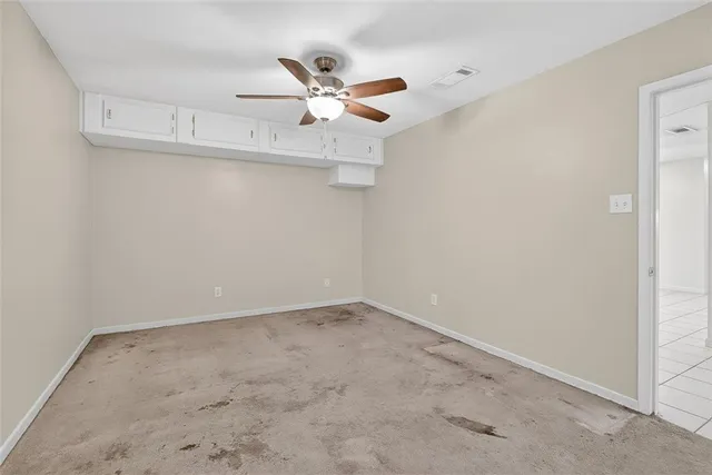 an empty room with a fan and a fan