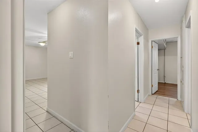 an empty room with wooden floor closet and windows