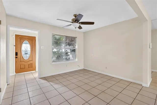 a view of an empty room and chandelier fan
