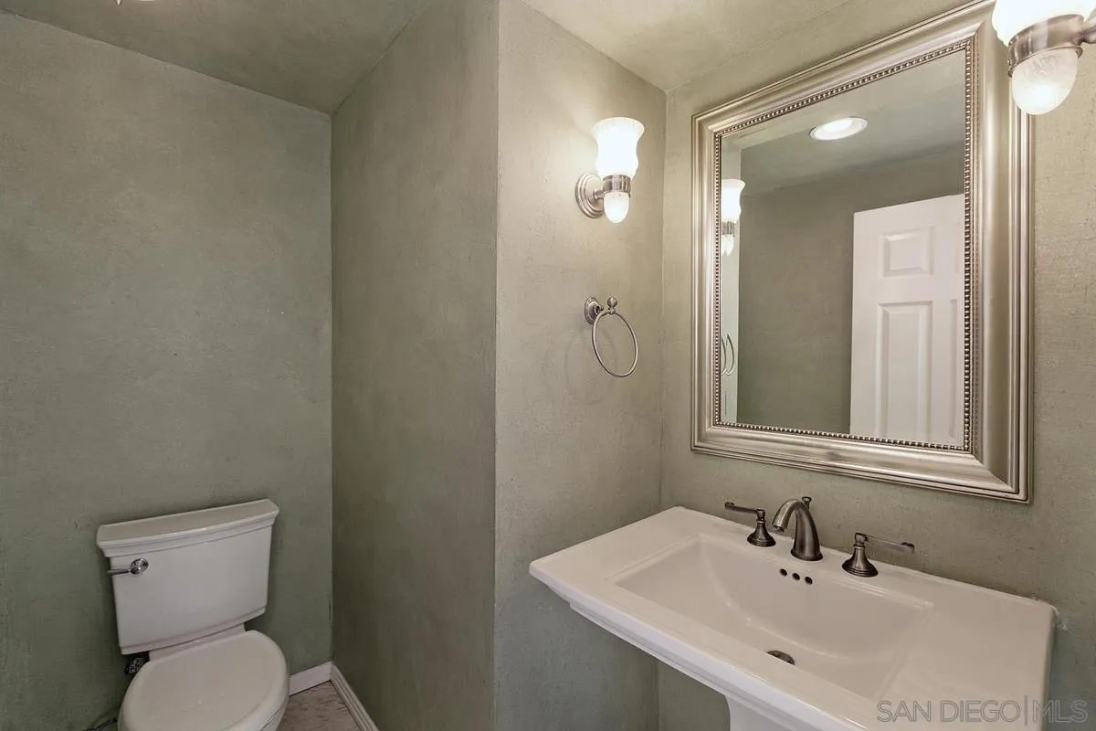 3919 Pringle Street San Diego, CA 92103 - Photo 14 of 37 a bathroom with a toilet a sink and mirror