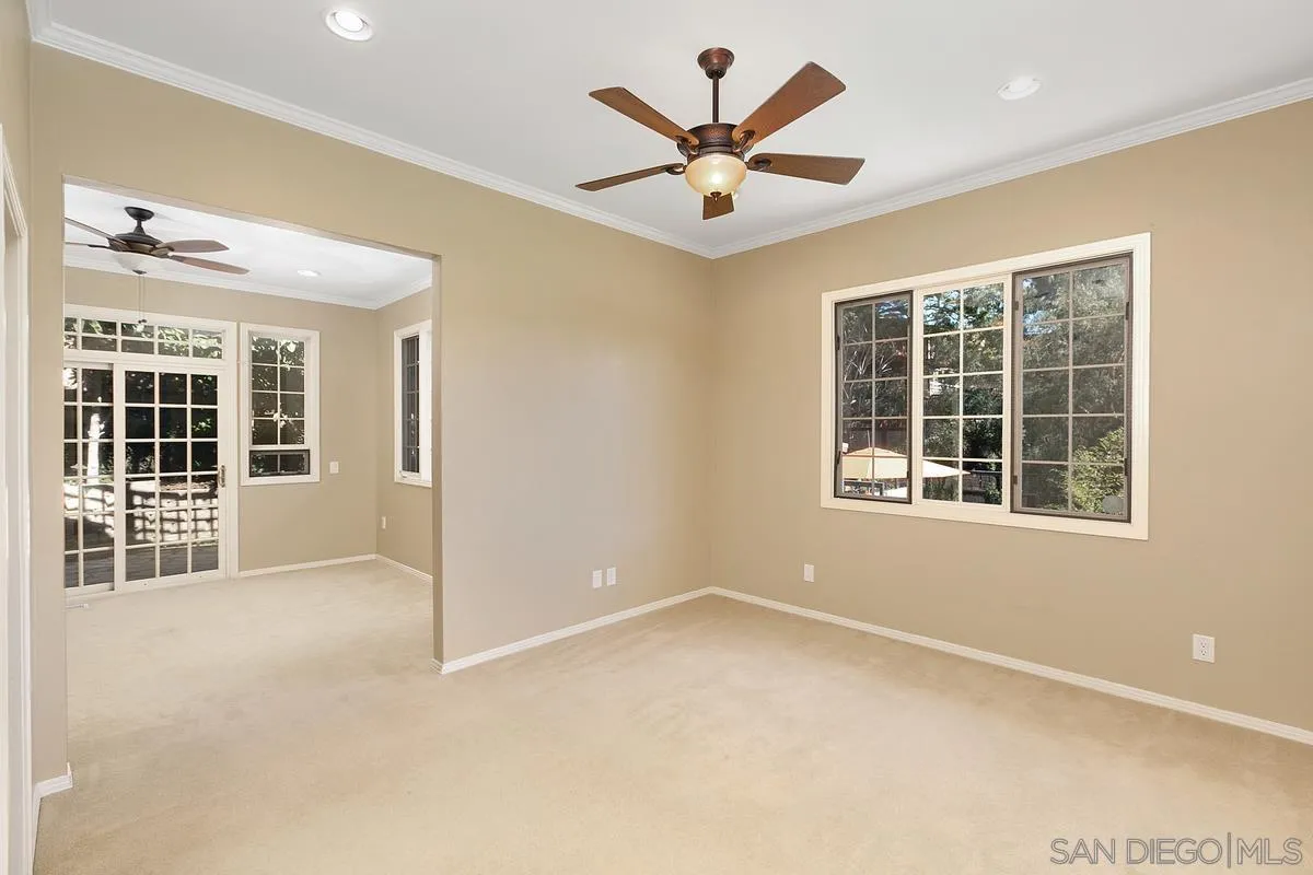 3919 Pringle Street San Diego, CA 92103 - Photo 22 of 37 an empty room with a ceiling fan and windows