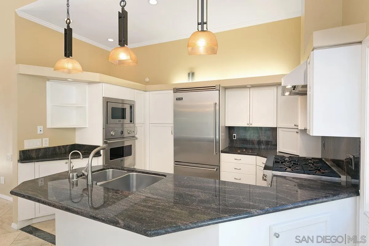 3919 Pringle Street San Diego, CA 92103 - Photo 5 of 37 a kitchen with stainless steel appliances granite countertop a sink a stove and a wooden cabinets