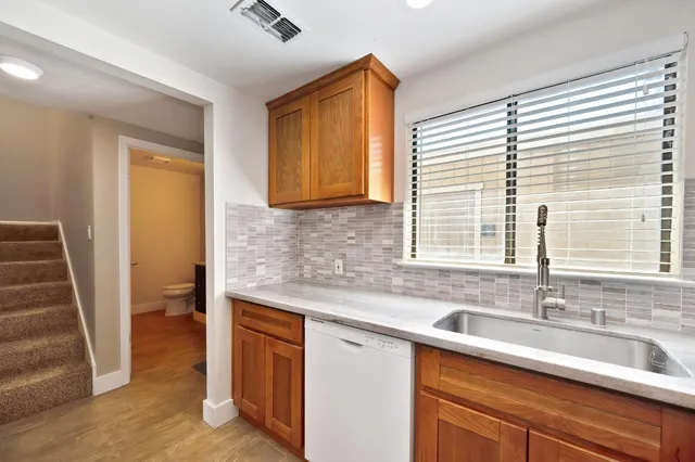 a kitchen with stainless steel appliances granite countertop a sink and a window