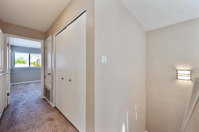a view of a hallway with wooden floor and a living room
