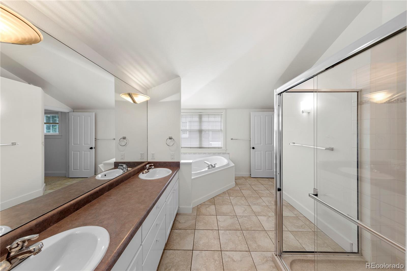3056 8th Street Boulder, CO 80304 - Photo 18 of 45 a spacious bathroom with a granite countertop tub sink and mirror