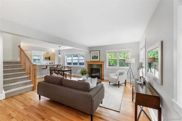 a living room with fireplace furniture and a wooden floor