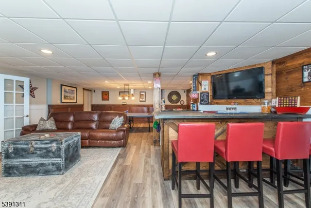 a living room with furniture a flat screen tv and kitchen view