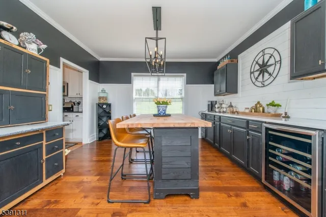 a dining room with wooden floor a chandelier a wooden table and chairs