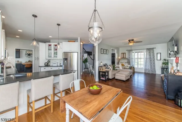 a living room with furniture kitchen view and a chandelier