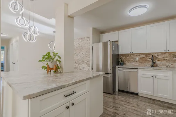 a kitchen with stainless steel appliances white cabinets and wooden floor