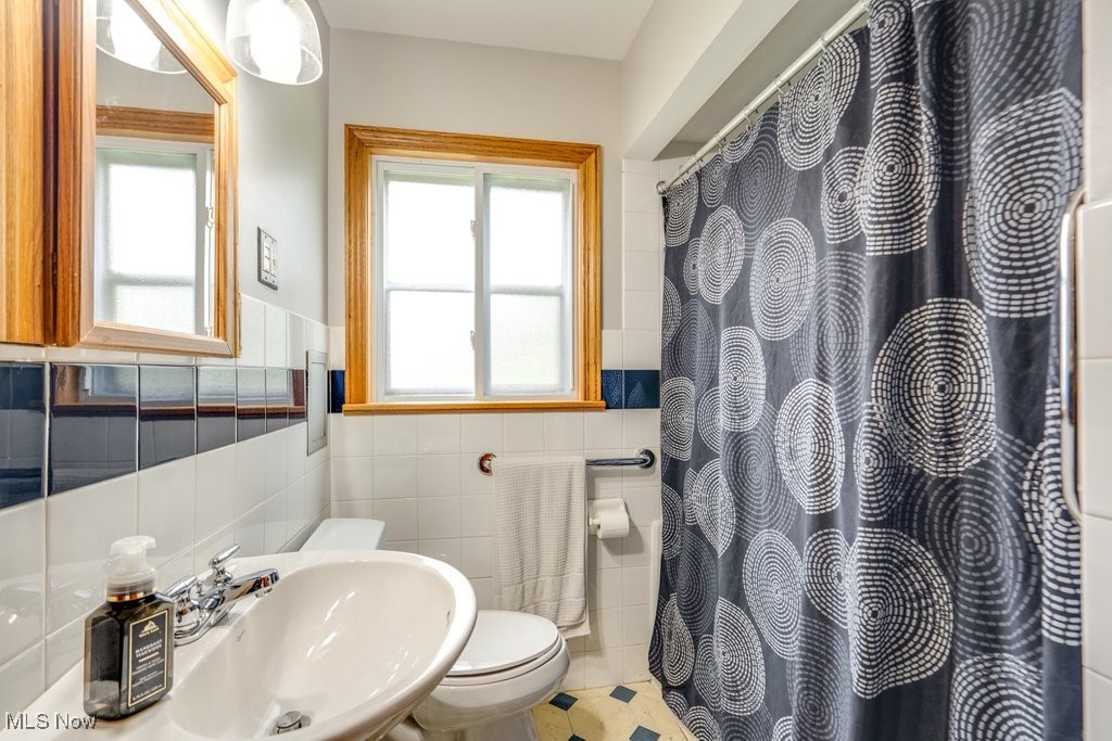 11339 Ridge Road North Royalton, OH 44133 - Photo 16 of 22 Full bath with tile walls, a wainscoted wall, plenty of natural light, and a shower with shower curtain