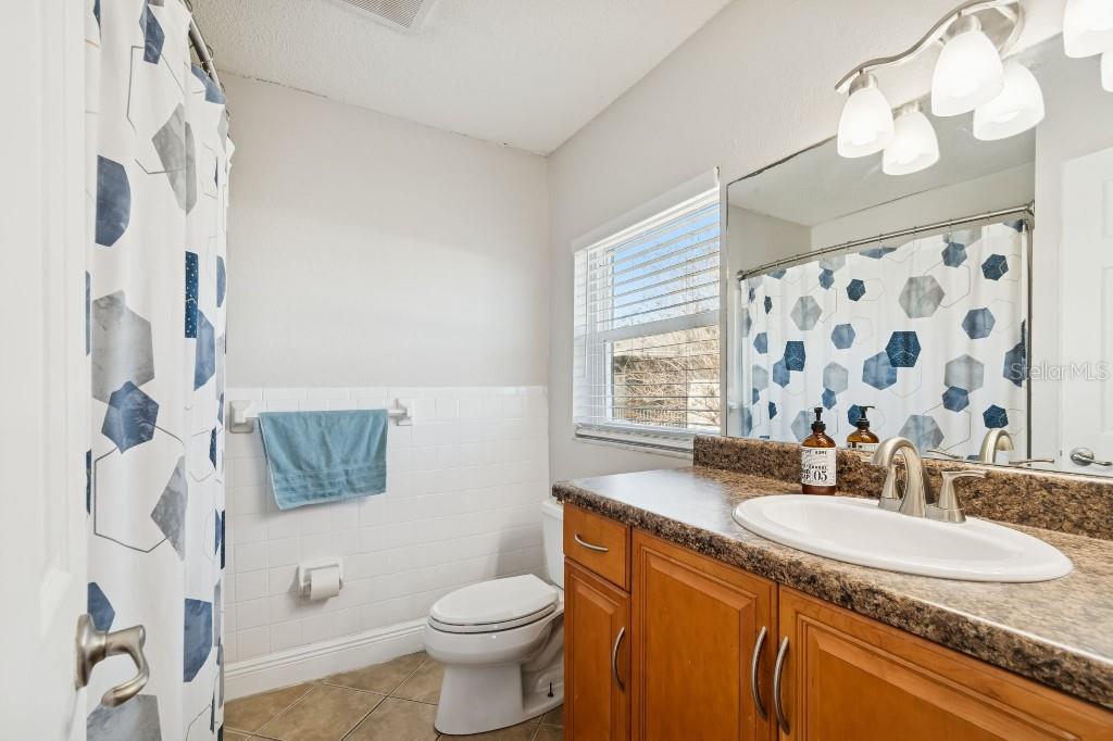 13125 Wilcox Road, Unit 6205 Largo, FL 33774 - Photo 30 of 48 a bathroom with a granite countertop sink mirror vanity and toilet