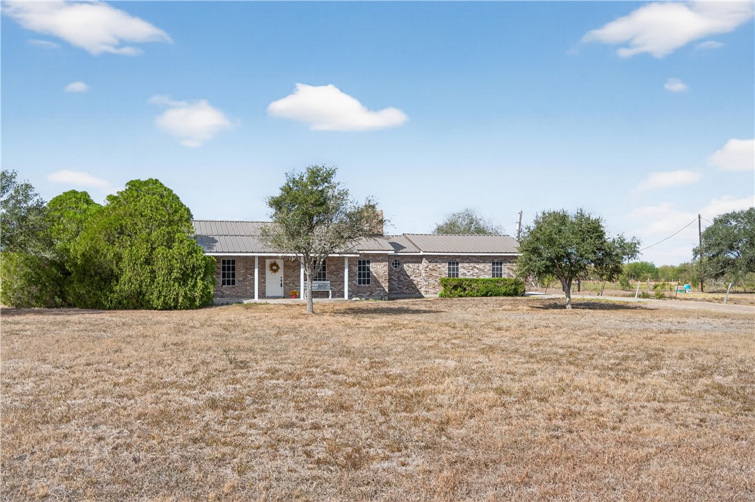 a front view of house with yard and trees in the background