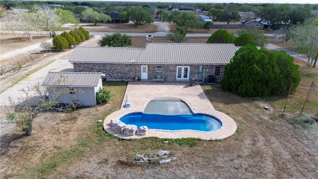 an aerial view of a house with a yard and lake view