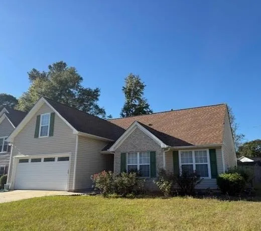 a front view of a house with a garden