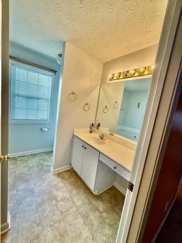 a bathroom with a tub sink and mirror