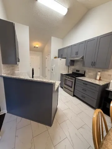 a kitchen with stainless steel appliances a sink a stove a microwave a sink a refrigerator and cabinets