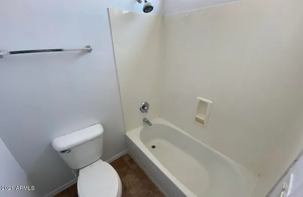 a white toilet sitting next to a bath tub