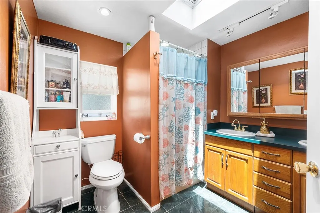 17701 Avalon, Unit SP124 Carson, CA 90746 - Photo 15 of 32 a bathroom with a granite countertop toilet sink and shower