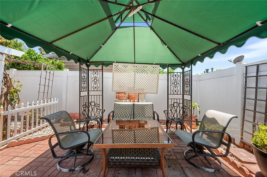17701 Avalon, Unit SP124 Carson, CA 90746 - Photo 20 of 32 a patio with tables and chairs and a umbrella