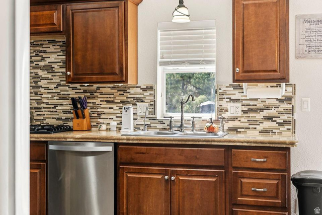 327 North Lodge Road Central, UT 84722 - Photo 14 of 45 Kitchen featuring wood cabinetry, stone-look countertops, and a mosaic tile backsplash