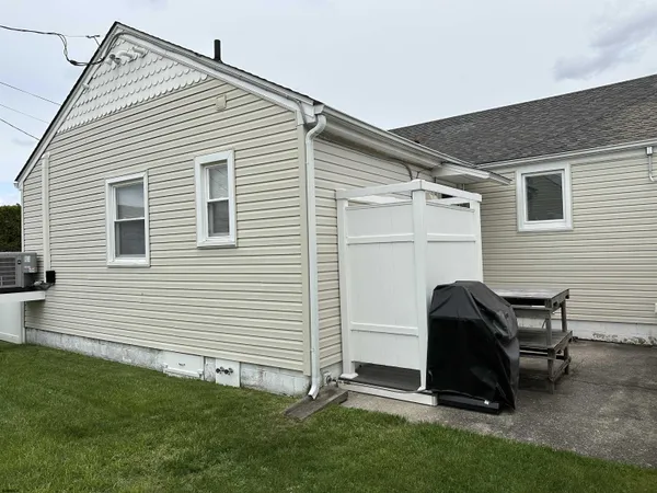 a view of backyard with a chair and a grill