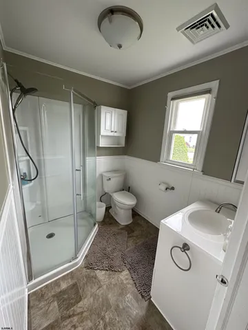 a bathroom with a sink a toilet and shower