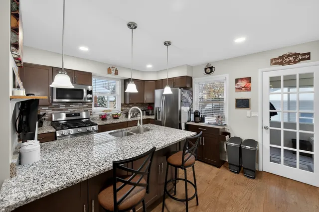 a kitchen with stainless steel appliances granite countertop a kitchen island a table and chairs
