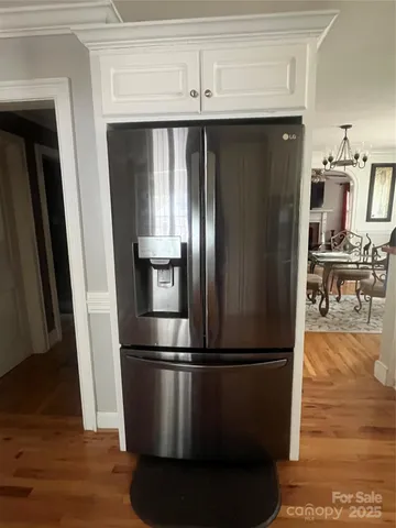 a kitchen with stainless steel appliances wooden floor and a refrigerator